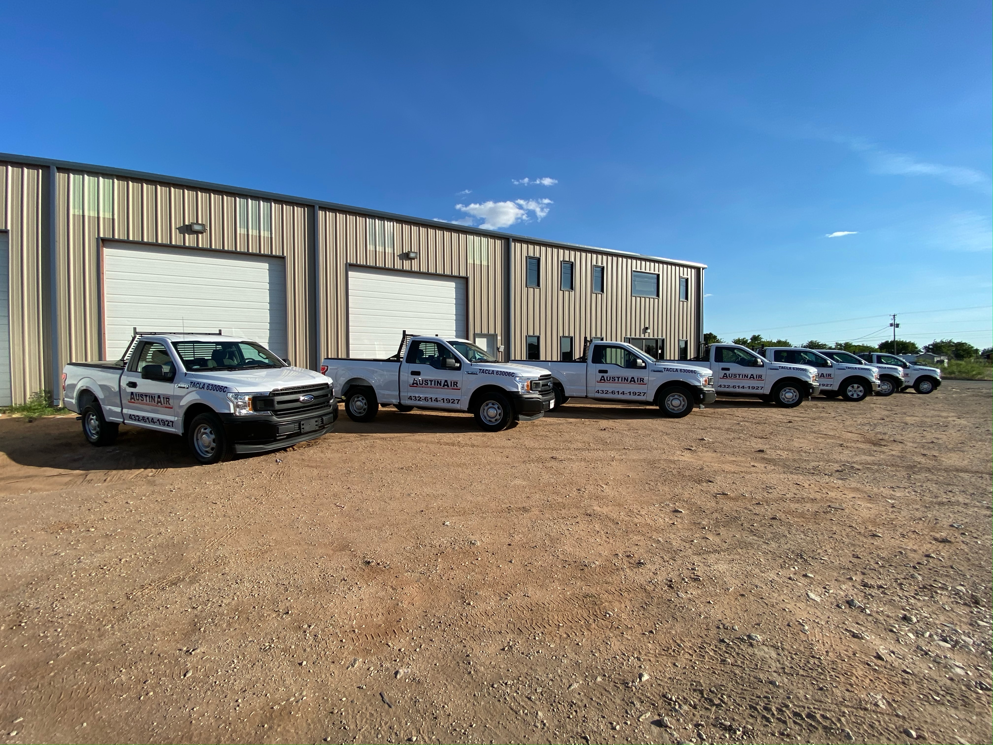 Line of Austin Air service trucks and vans parked outdoors.
