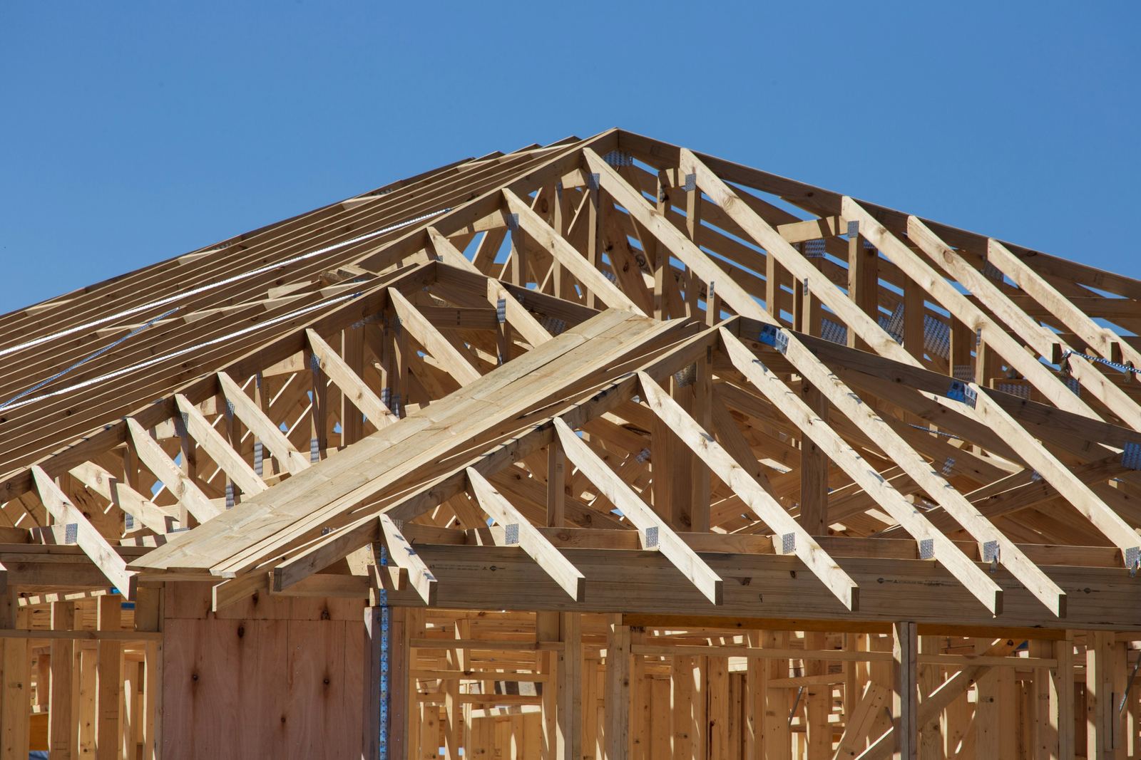 Wood framing and roof trusses of a house under construction.