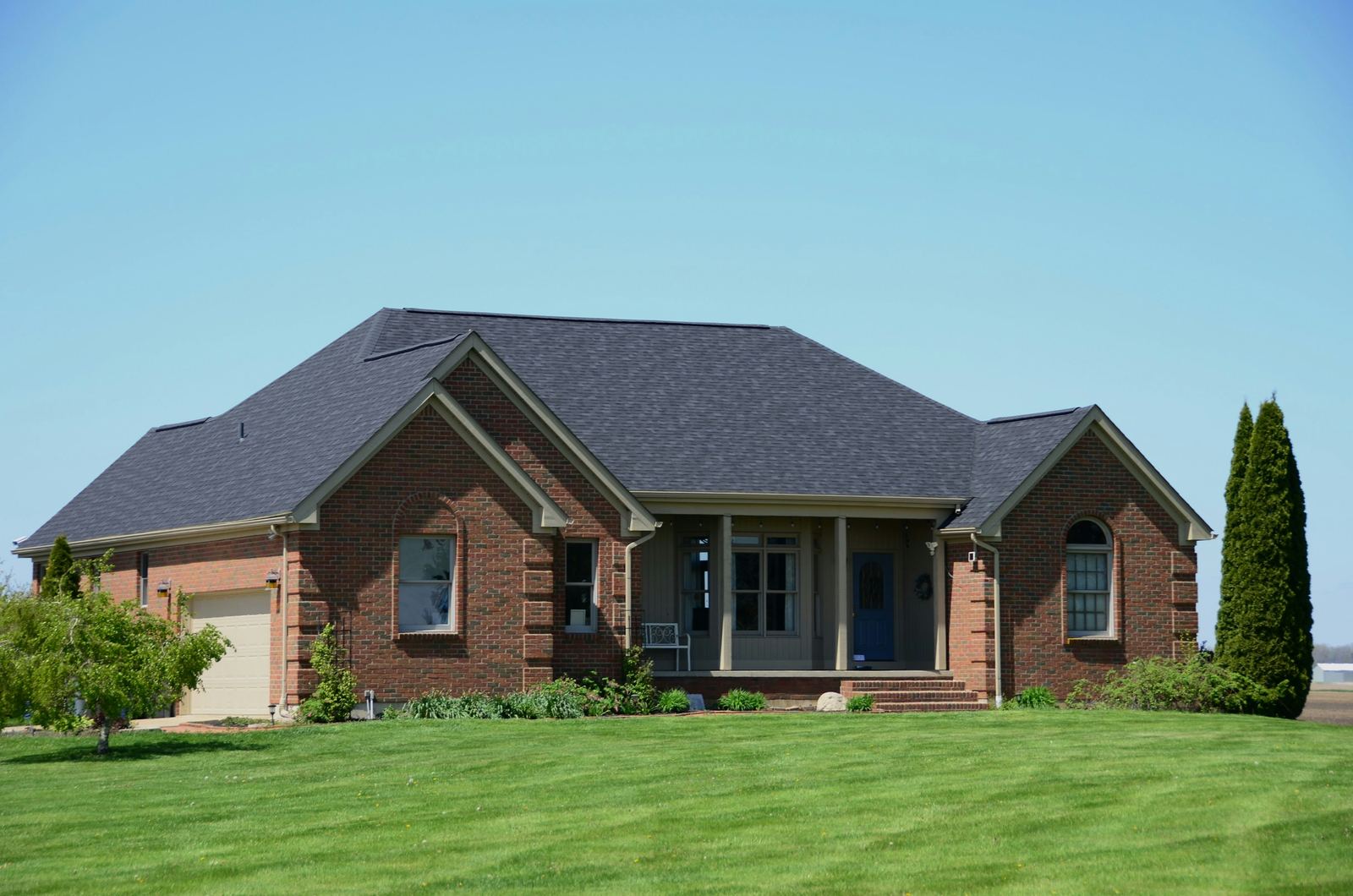 Brick house exterior under a blue sky.