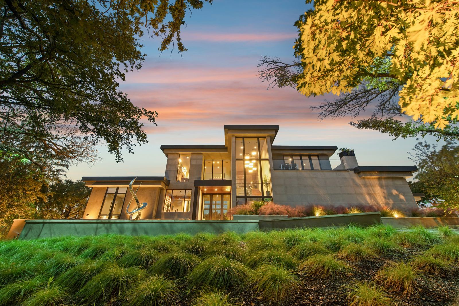 Finished house at dusk with interior lights on.